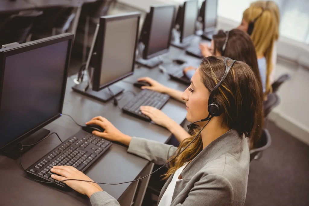 Call center agents working at their desks, wearing headsets and using computers, representing the future of BPO services